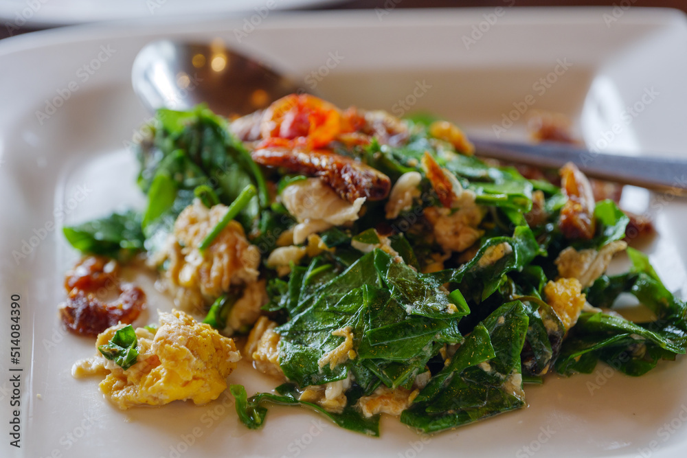 Stir-fried Malindjo Leaves with Egg serve on white plate. Stir-fried Malindjo Leaves with Egg serve on white plate.