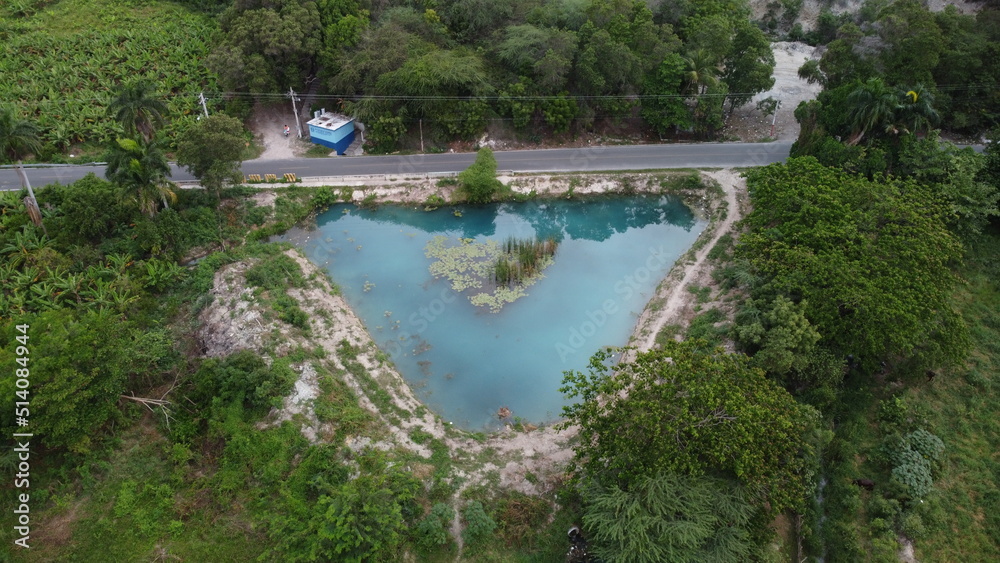 Laguna en forma de diamante, con agua azul turqueza y una pequeña isleta en el centro, ademas de tener un bosque verde alrededor Laguna en forma de diamante, con agua azul turqueza y una pequeña isleta en el centro, ademas de tener un bosque verde alrededor