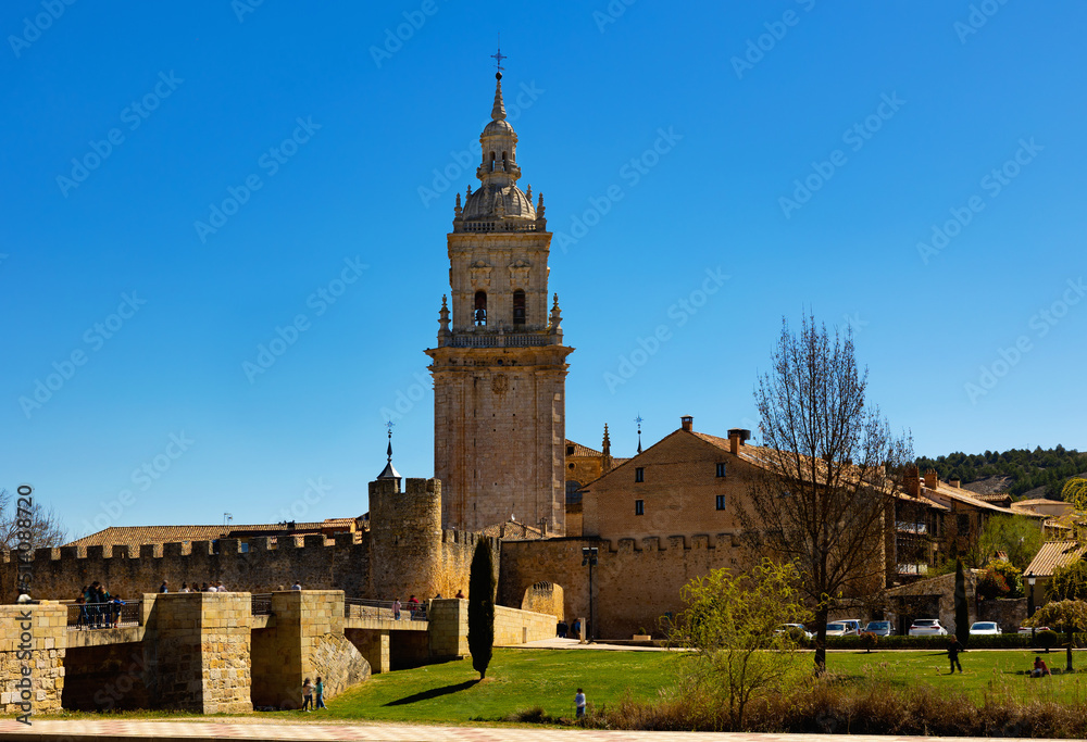 Scenic spring landscape with view of medieval Roman Catholic Cathedral of Assumption of El Burgo de Osma on bank of river Ucero, Spain.