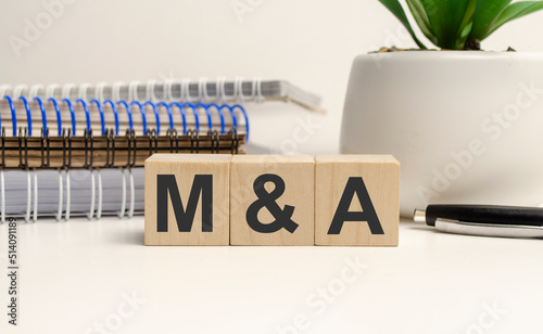wooden cubes with the word M and A on wooden background