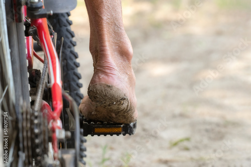 Bare foot of a man on the pedal of a red bicycle.Extreme cycling.