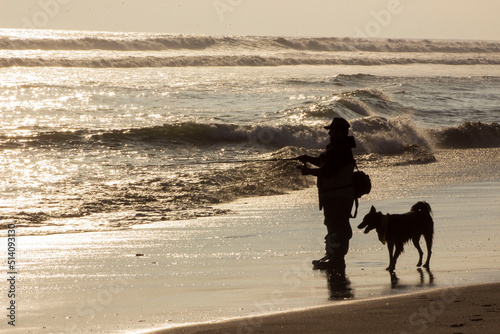fisherman with his dog on the beach 