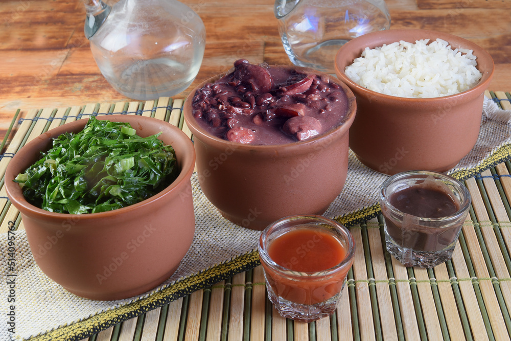 Feijoada typical Brazilian food, beans with pork bacon, orange rice and flour, chili sauce and crackling Feijoada typical Brazilian food, beans with pork bacon, orange rice and flour, chili sauce and crackling