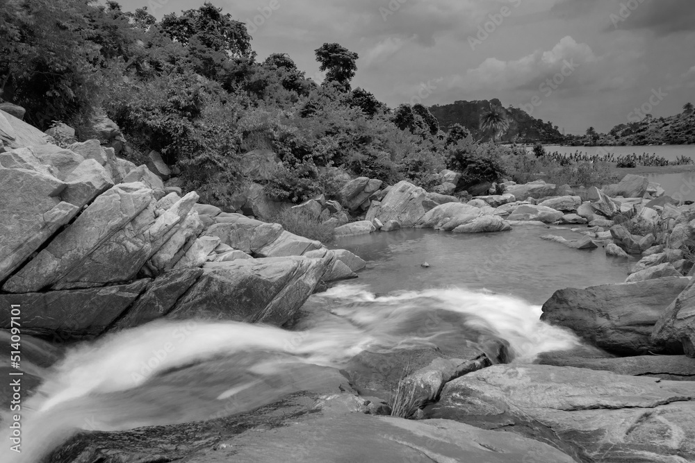 Beautiful Ghatkhola waterfall having full streams of water flowing downhill amongst stones , duriing monsoon due to rain at Ayodhya pahar (hill) - at Purulia, West Bengal, India. B&W image.