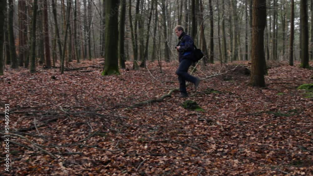 Man with photo camera hiking through forest in autumn Man with photo camera hiking through forest in autumn