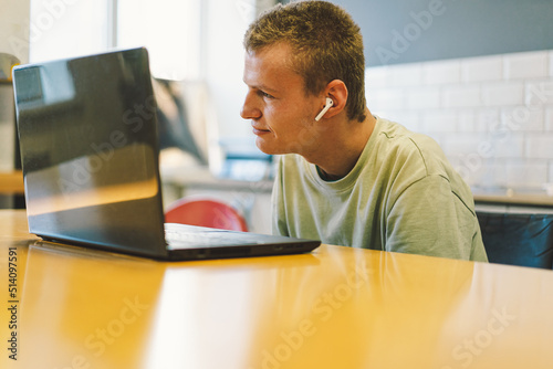 Handsome young invalid disabled man talking on mobile phone in kittchen. Person with disabilities. Video chat or call. Portrait of man handicapped with disabilities. Optimistic smiling disabled man. photo