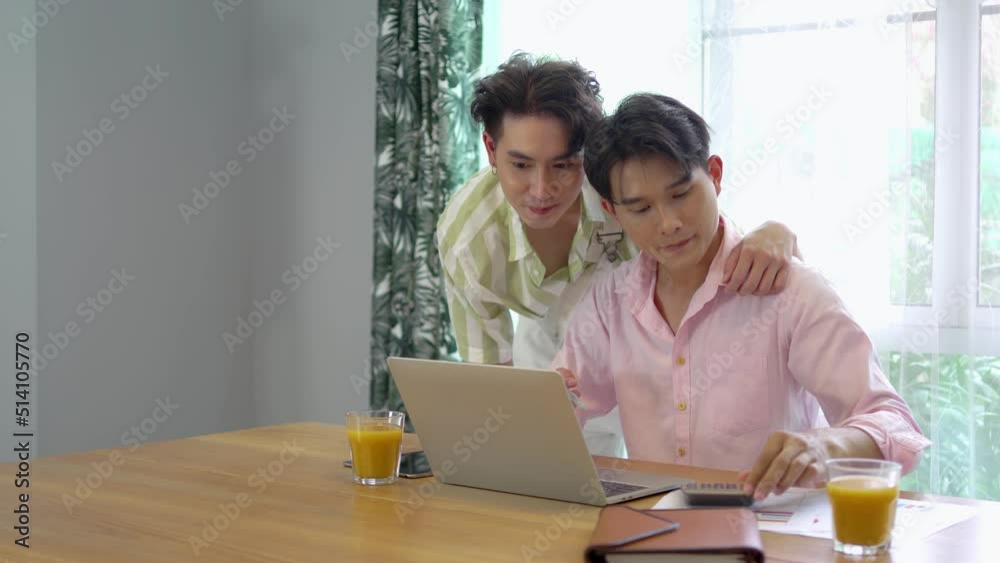 Slow motion of young asian gay hugging and takes care of his boyfriend while working on his laptop at home, lgbt couple Slow motion of young asian gay hugging and takes care of his boyfriend while working on his laptop at home, lgbt couple