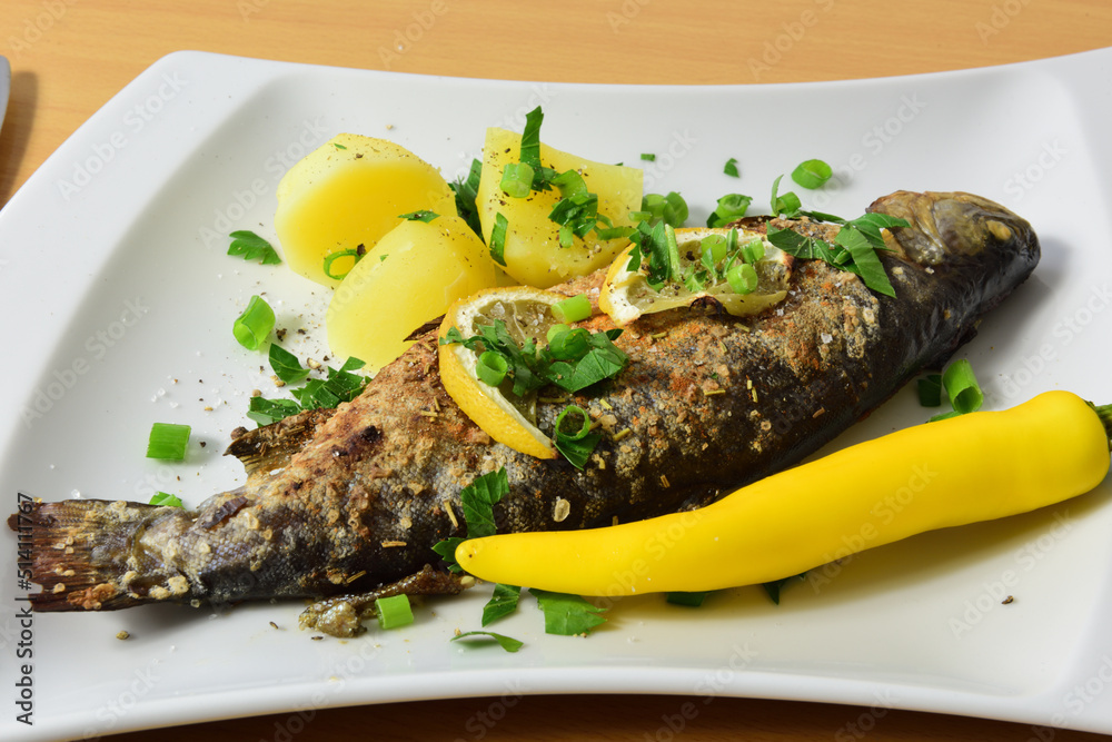 gebratene Forelle mit Petersilienkartoffeln und Zitronen Stock Photo ...