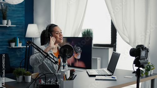 Cheerful popular creative content creator ending live podcast stream while sending kisses to public. Social media influencer saying goodbye to audience while sitting at home studio desk.