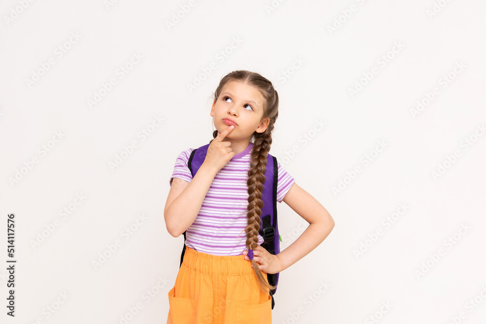 A little girl with pigtails and shorts with a school backpack on her back on a white isolated background. Preparatory summer courses for children. A little girl with pigtails and shorts with a school backpack on her back on a white isolated background. Preparatory summer courses for children.