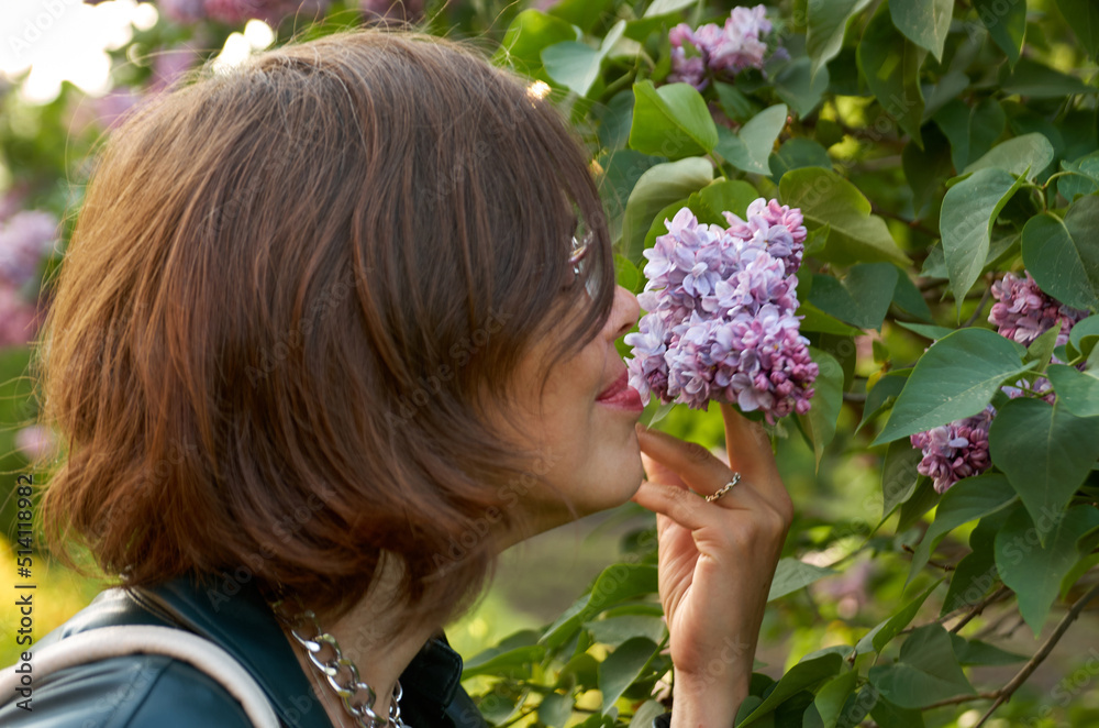 Close up portrait of beautiful woman smelling purple lilac Close up portrait of beautiful woman smelling purple lilac