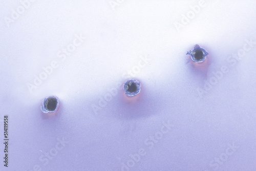 bullet holes on a veri peri color metal.Selective focus,closeup,copy space.