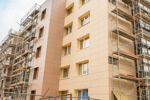 Tableau sur toile Tall building under construction with scaffolds