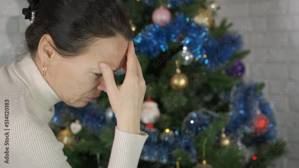 Woman Christmas trouble at home. A woman with life trouble stay by the Christmas tree in the room. Woman Christmas trouble at home. A woman with life trouble stay by the Christmas tree in the room.