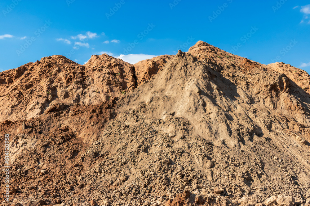 Heap of earth sand and clay at the construction site against the sky. Earthworks at the construction site.