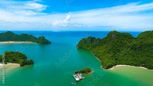 Aerial view of summer tropical islands in the ocean as white sand beach with tourists and turquoise water background