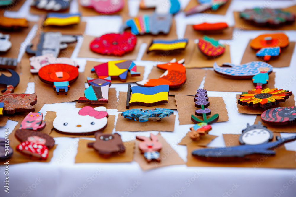 Ukrainian symbols, key rings, badges on a white table, with selective focus