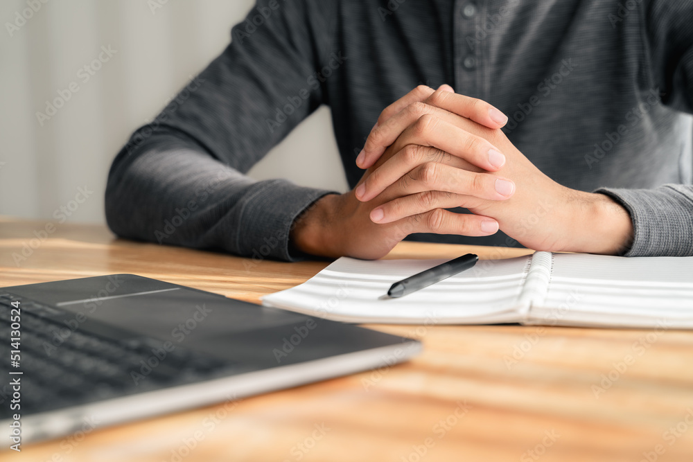 Close up of man clasped hands clenched together on table, businessman preparing for job interview, concentrating before important negotiations, thinking or making decision, business concept Close up of man clasped hands clenched together on table, businessman preparing for job interview, concentrating before important negotiations, thinking or making decision, business concept