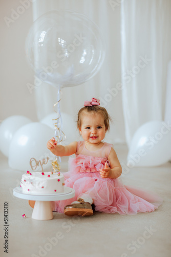 Photography Girl in pink dress posing with birthday cake and balloons in the studio