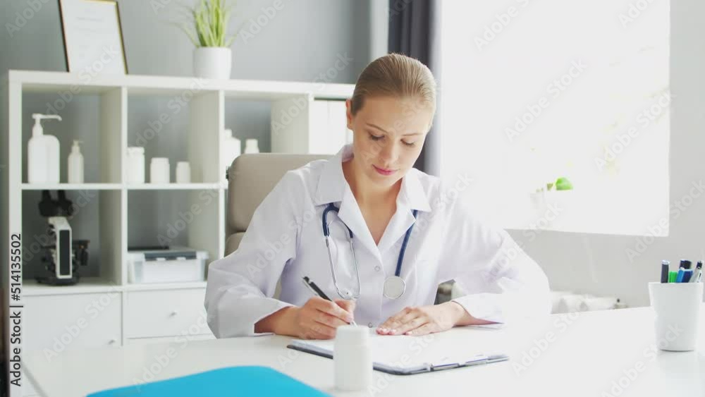 Doctor Works in the Medical Office. Woman in White Coat. Workplace of a Professional Female Therapist in a Hospital or Clinic. Healthcare and Medicine. Doctor Works in the Medical Office. Woman in White Coat. Workplace of a Professional Female Therapist in a Hospital or Clinic. Healthcare and Medicine.