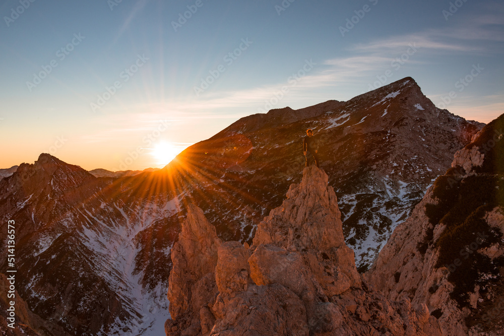 Male hiker at the top of the mountain at sunset