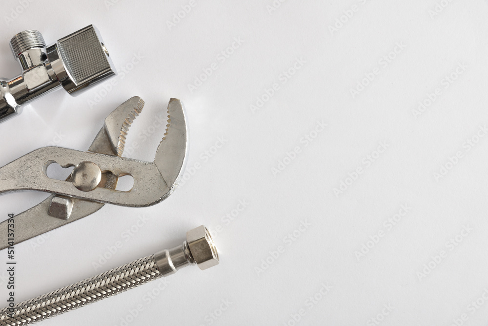 Plumbing background with wrench hose and parrot beak pliers Plumbing background with wrench hose and parrot beak pliers