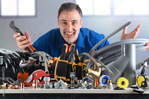 Plumbing material and smiling plumber behind in industrial warehouse photo