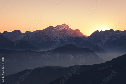 Foggy sunset in the mountains. Mist is covering the hills in the early evening. © gljivec
