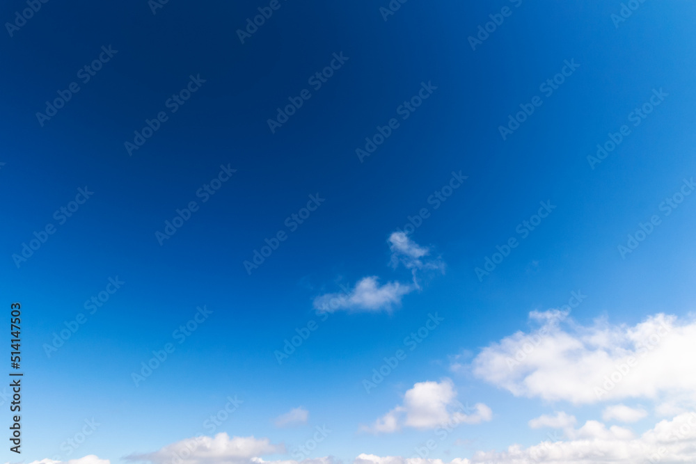 Fototapeta premium blue sky background. white fluffy clouds above horizon. sunny summer weather at high noon