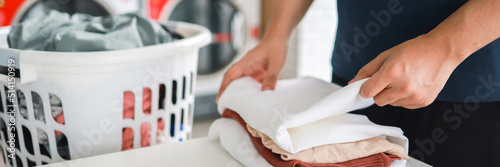 Картината върху платно Man doing launder holding basket with dirty laundry of the washing machine in the public store