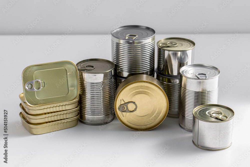 food, eating and preserve concept - close up of tin cans with preserves on table food, eating and preserve concept - close up of tin cans with preserves on table
