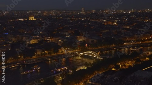 Boats sailing on the Seine near the Passerelle Debilly footbridge and panorama of Paris at night photo