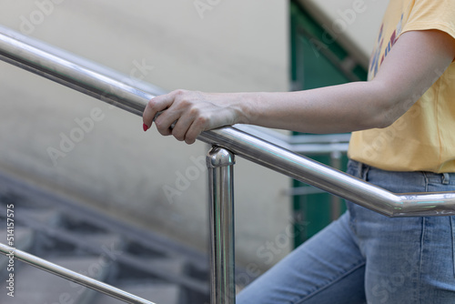 Fotografia woman climbing the stairs holding the handrail