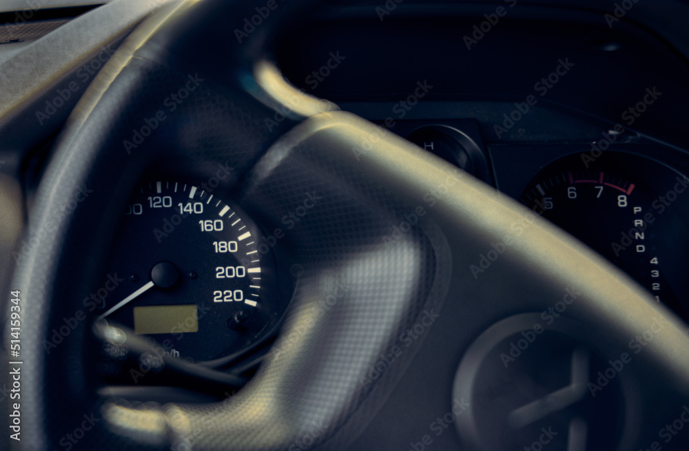 Closeup photo of car speedometer and steering wheel