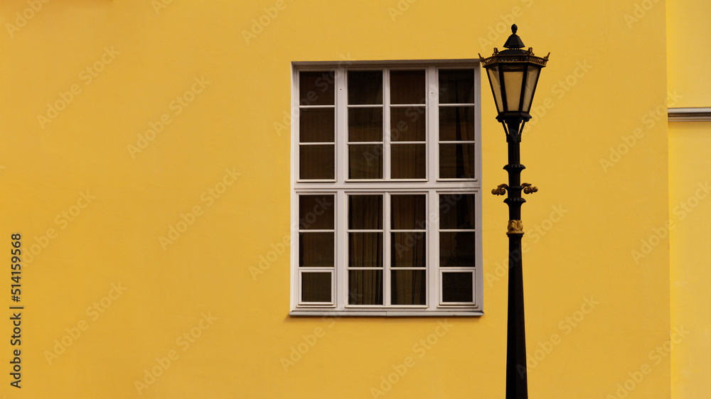 white wooden window and old lantern on yellow wall
