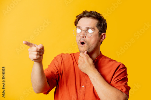 Stylish guy in eyeglasses on yellow background