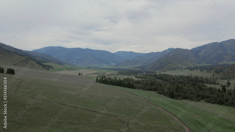 Rural fields and mountains under blue sky with white clouds in Altai Rural fields and mountains under blue sky with white clouds in Altai