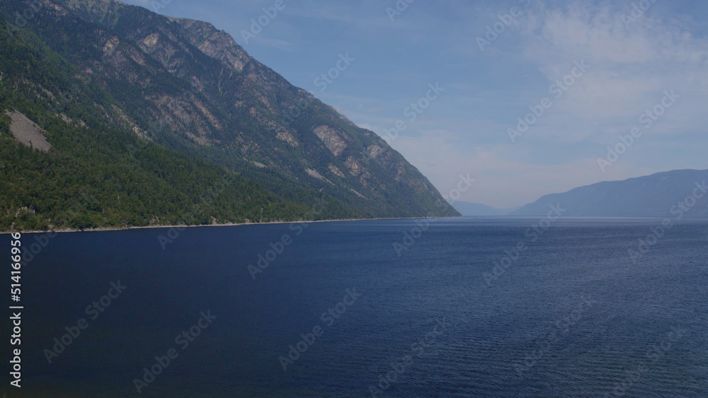Lake Teletskoye between mountains with blue clear sky in Altai