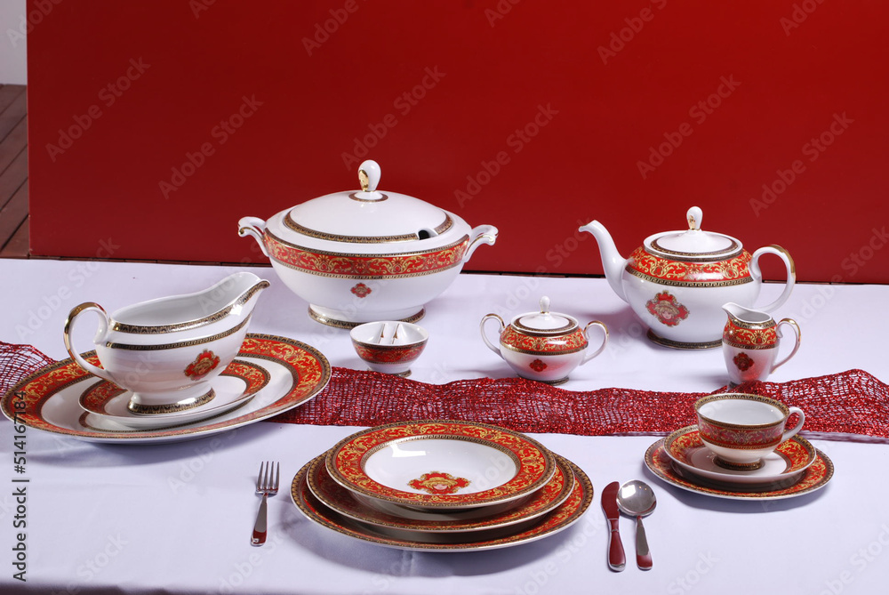 Fototapeta premium White premium porcelain tableware plates ready for dinner. Elegant table setting at home or restaurant with luxury dinnerware