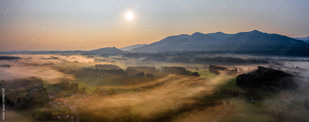 Sunset Panorama with drone at the Bavarian Alps. Mist and fog at the ground