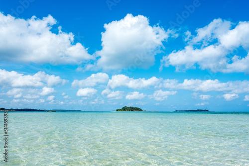 Nature seascape view of beautiful tropical beach and sea in sunny day with some clouds and islands in the horizon. Belitung, Indonesia