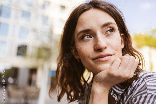 Photography pensive young woman sitting in city looking to the side