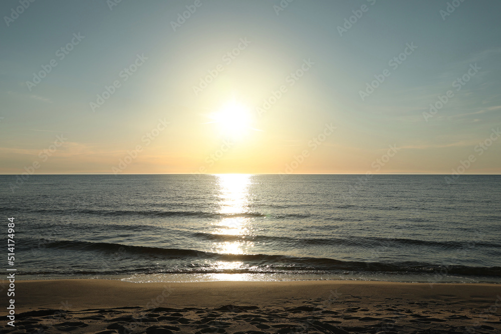 Picturesque view of sandy beach and sea at sunset