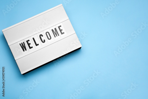 Lightbox with word Welcome on light blue background, top view. Space for text