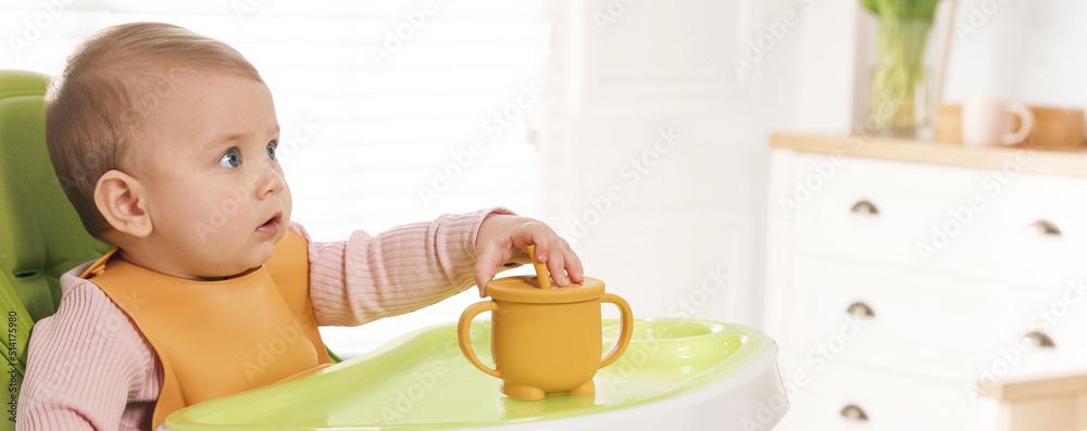 Cute little baby wearing bib in highchair at home, space for text. Banner design