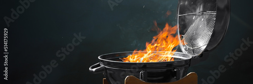 Foto New modern barbecue grill with burning firewood on dark background