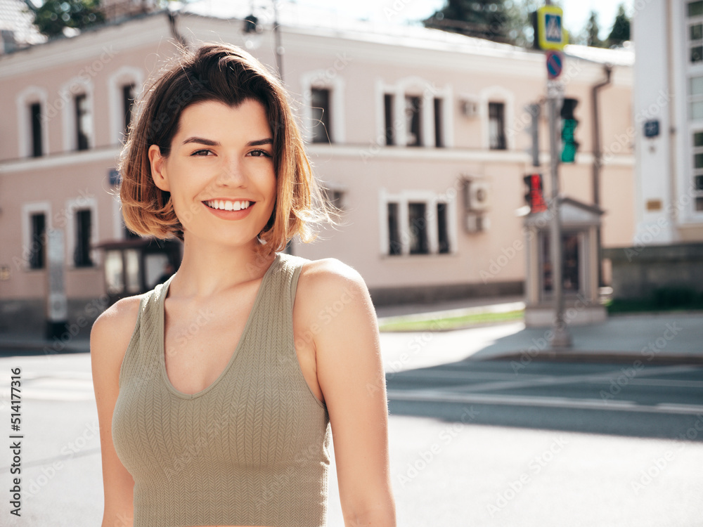 Young beautiful smiling hipster woman in trendy summer clothes. Sexy carefree model posing on the street background at sunset. Positive brunette female. Cheerful and happy Young beautiful smiling hipster woman in trendy summer clothes. Sexy carefree model posing on the street background at sunset. Positive brunette female. Cheerful and happy