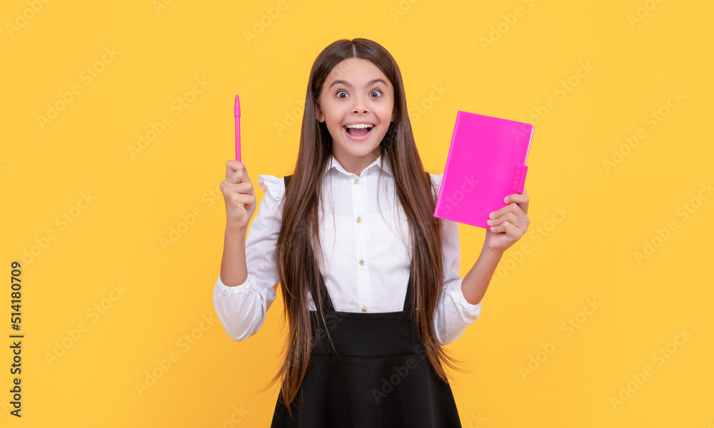 Happy girl child got idea holding book and pointing pen up yellow background, eureka Happy girl child got idea holding book and pointing pen up yellow background, eureka