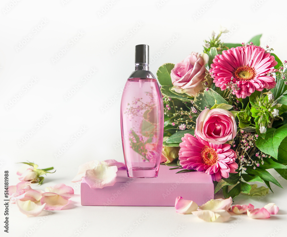 Pink perfume glass spray bottle on podium with beautiful flower bouquet at white background. Front view Pink perfume glass spray bottle on podium with beautiful flower bouquet at white background. Front view