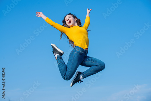 happy teen girl jumping on sky background